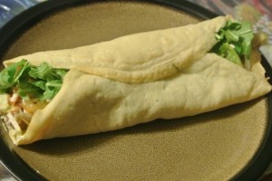 Brown rice wrap with baby arugula, hummus, roasted leeks & mushrooms, & Daiya cheese